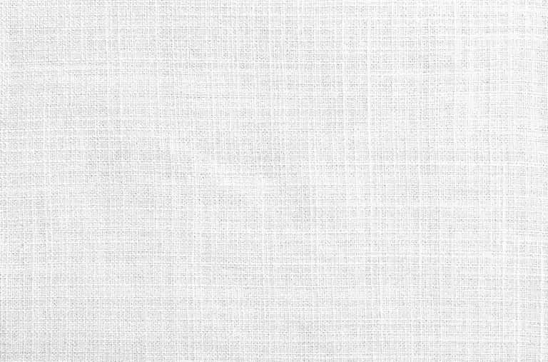 Nahaufnahme eines weißen Gewebes mit einem sichtbaren Kreuzmuster, das eine strukturierte und leicht unebene Oberfläche aufweist. Die Fäden bilden ein subtiles Gittermuster auf dem Stoff.
