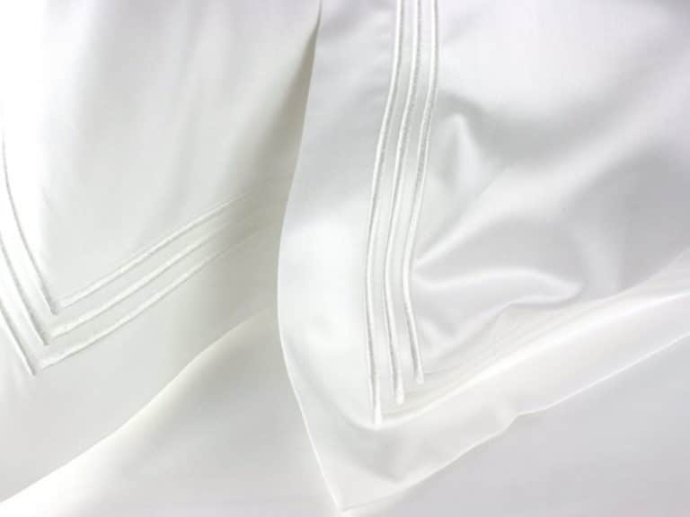 Close-up of Peter Reed's 210TC Percal bed linen, characterized by a smooth, silky texture and a subtle stripe design that highlights its softness and elegant folds.