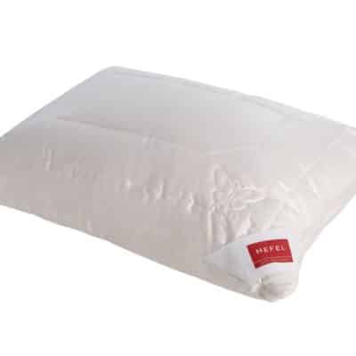 Ein weiches, weißes, rechteckiges Kissen mit Steppmuster und rotem HEFEL-Label passt perfekt zur Guest House Stripe Leinen Bettwäsche von Libeco und sorgt für einen einladenden und eleganten Schlafzimmerstil.