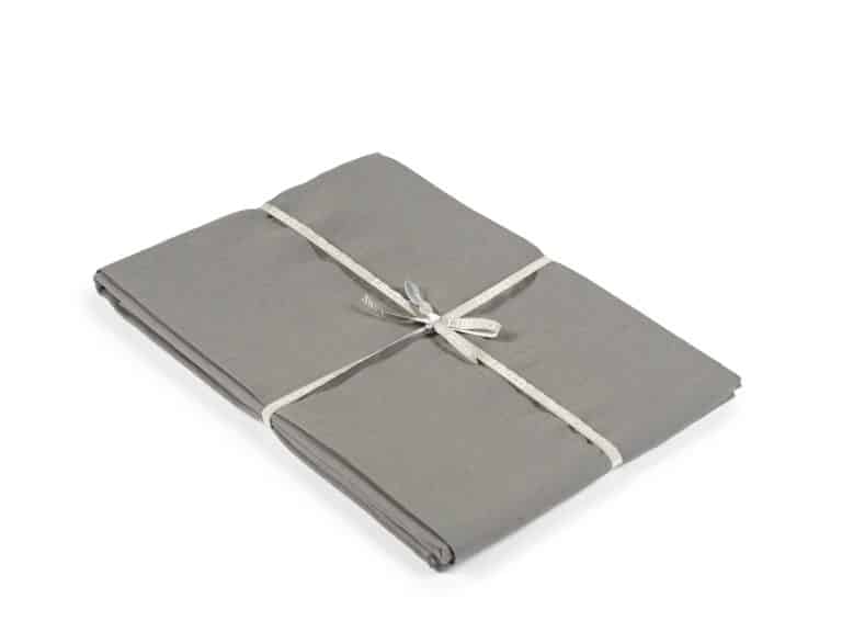 A neatly folded set of gray sheets, tied with a white ribbon, on a plain white background.