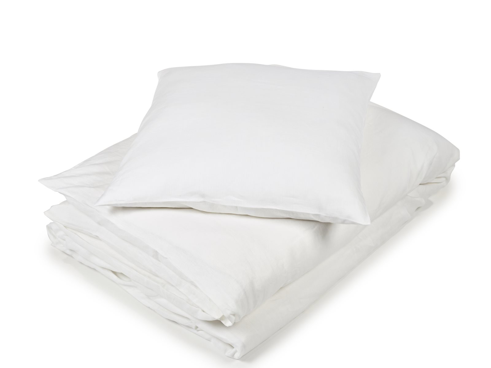 Eine ordentlich gefaltete weiße Bettdecke mit einem passenden Kissen darauf, beides vor einem schlichten weißen Hintergrund - so präsentiert sich die Madison White Farbige Leinen Bettwäsche von Libeco.