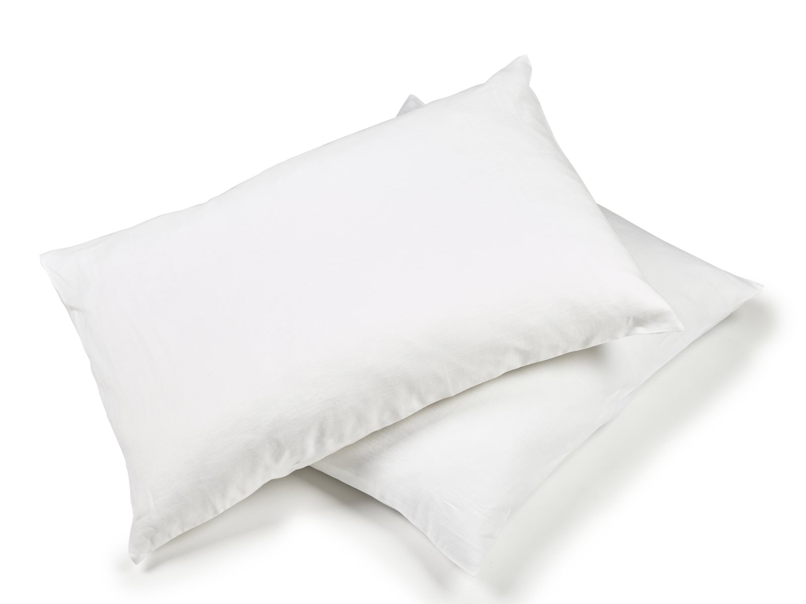 Zwei weiße Kissen mit glatten, musterfreien Bezügen sind auf einem unifarbenen Hintergrund gestapelt und ergänzen die Madison White Farbige Leinen Bettwäsche von Libeco.