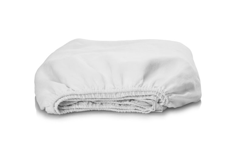 Ein ordentlich gefaltetes weißes Spannbettlaken mit elastischen Rändern auf weißem Hintergrund.