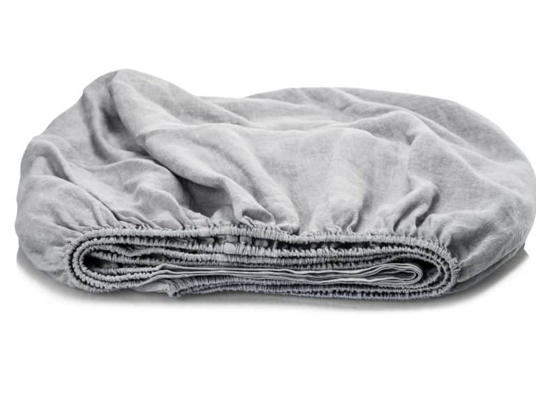 Das Heritage Oyster Bio Leinen Spannbettlaken von Libeco in hellgrau liegt ordentlich gefaltet mit sichtbarem Gummizug auf einer weißen Fläche.