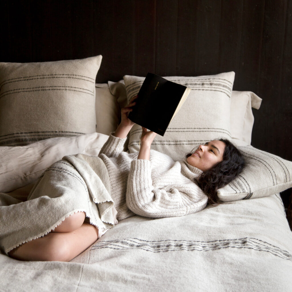Eine Frau, die im Bett liegt und ein Buch liest.