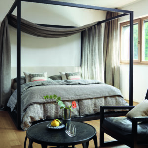 Ein Schlafzimmer mit einem Himmelbett und einem Stuhl.