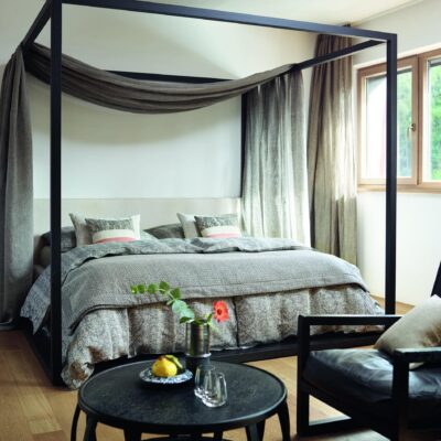 Ein Schlafzimmer mit einem Himmelbett und einem Stuhl.