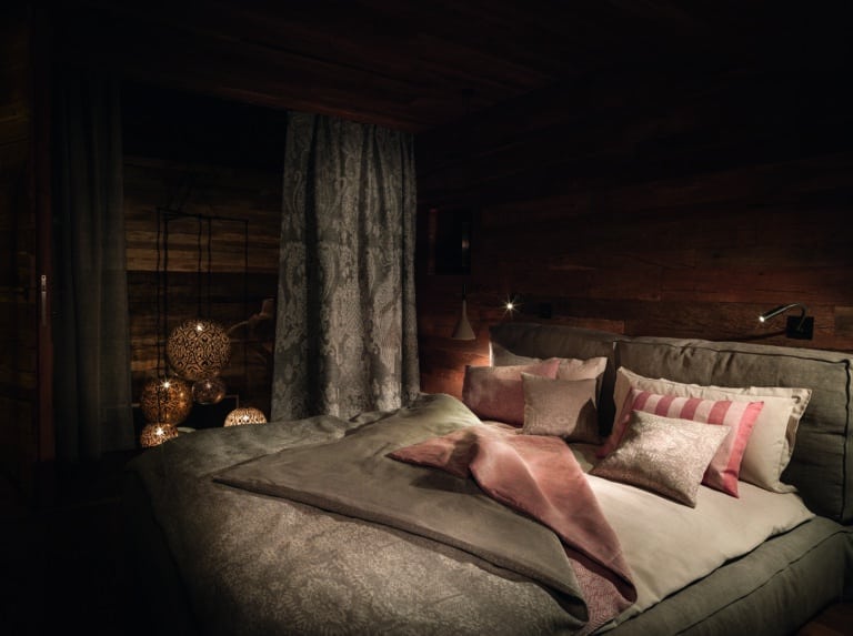 A bedroom with a large bed and wooden walls.