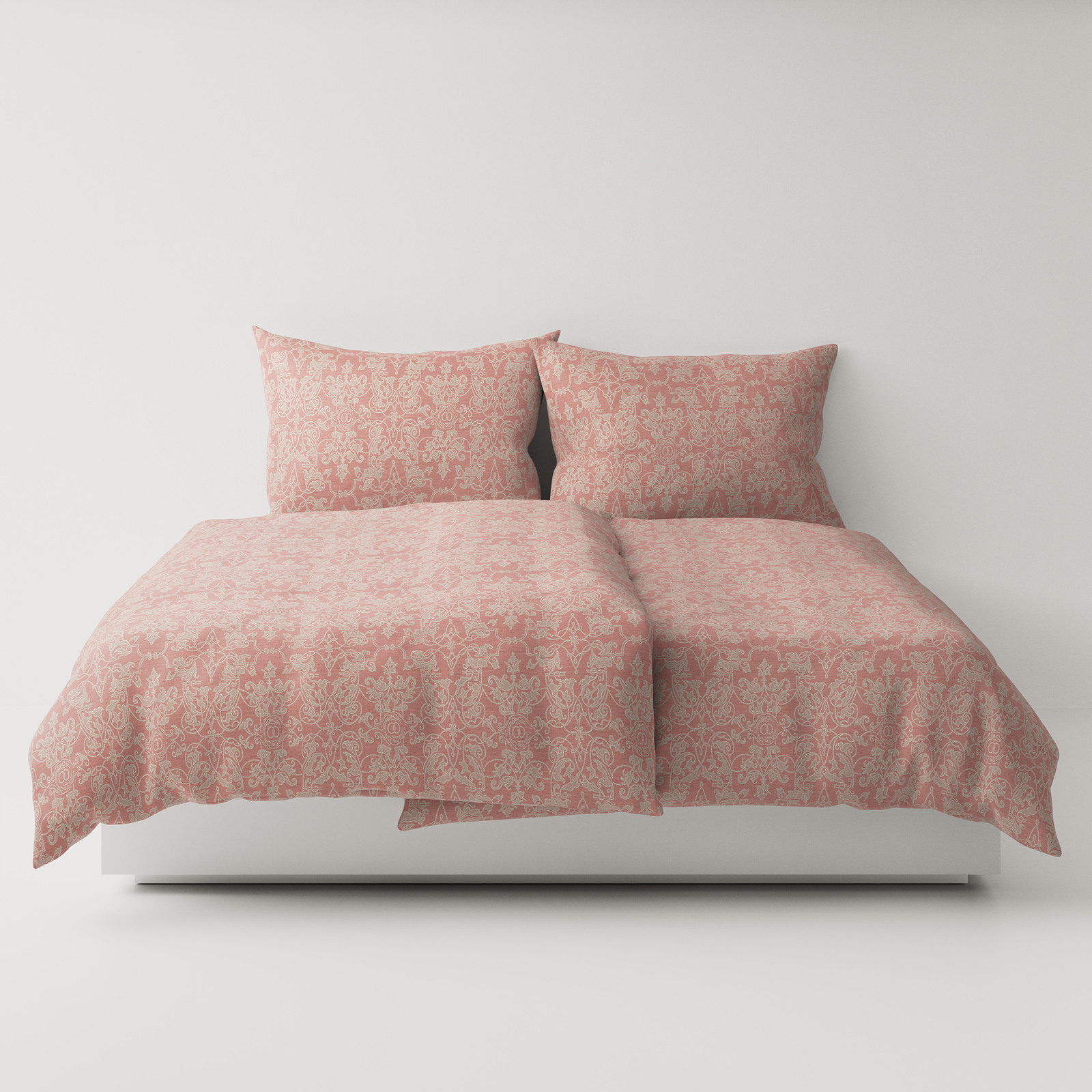 A bed with a pink comforter and two pillows.