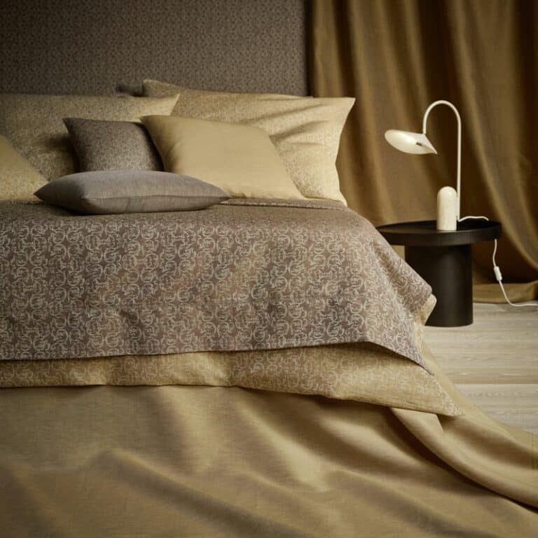 Ein Bett mit einer braunen Decke und Kissen.