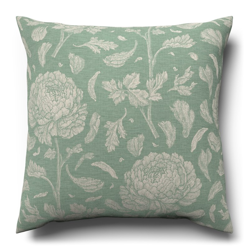 A green cushion with white flowers on it.
