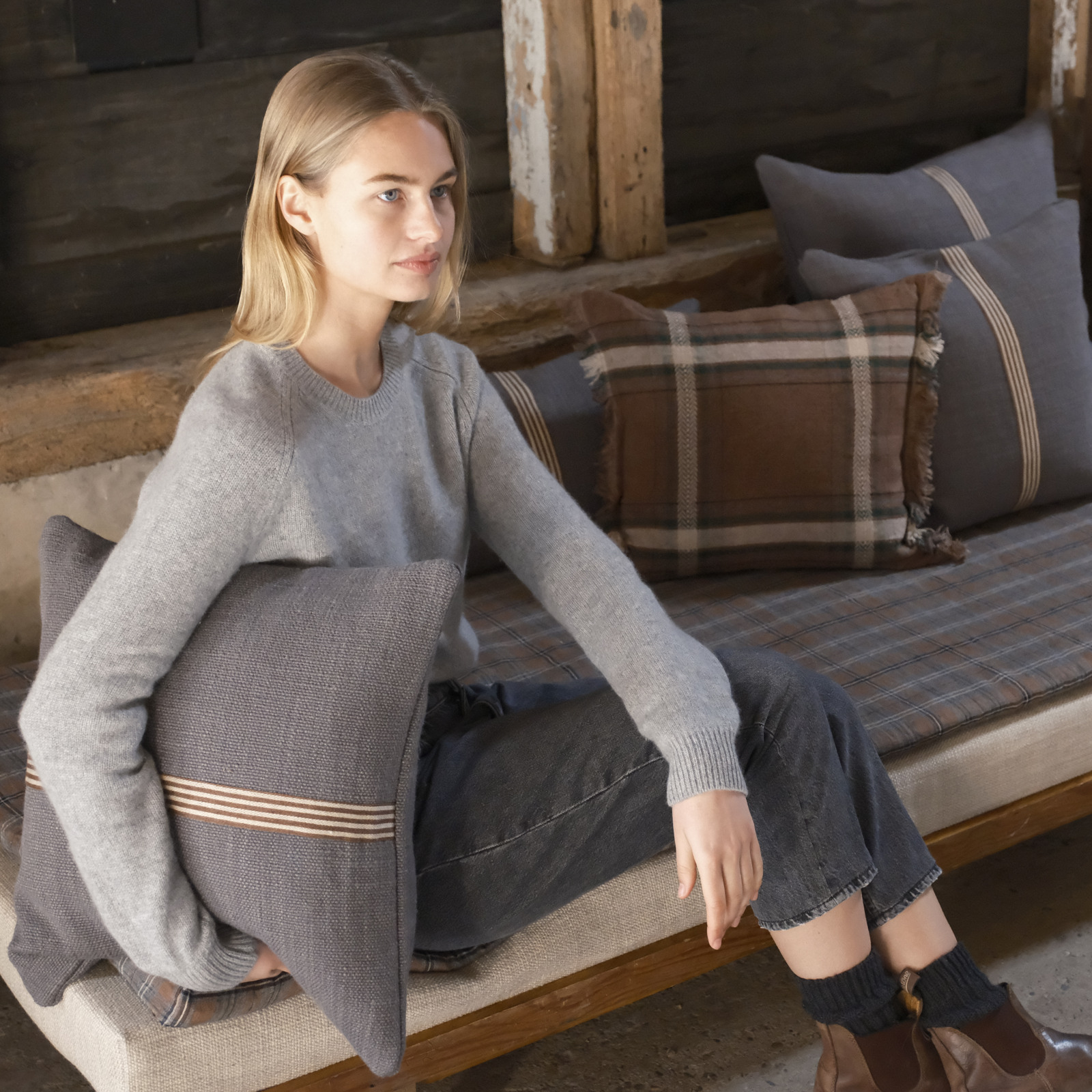 Eine Frau, die auf einer Bank vor einer Couch sitzt.