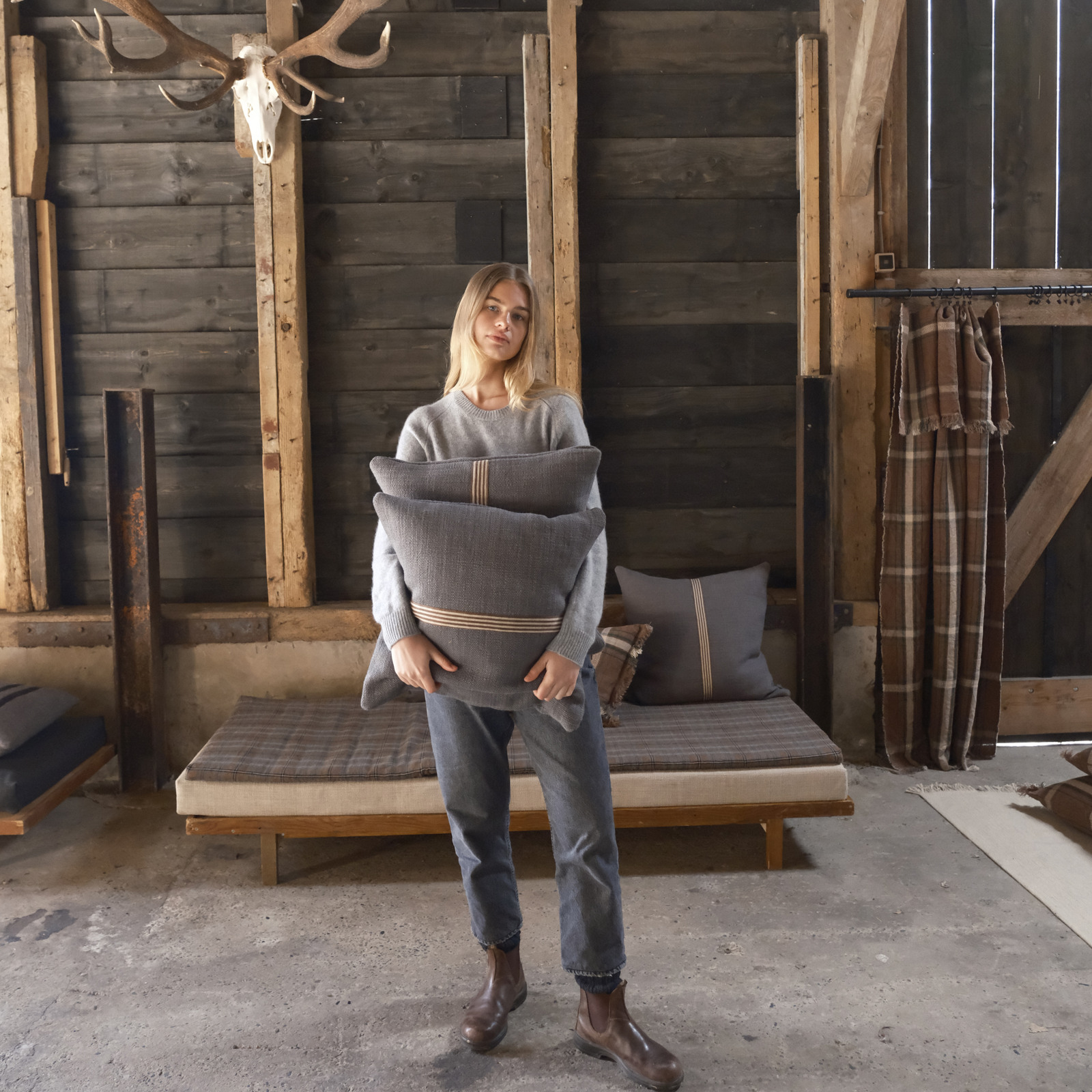 Eine Frau, die in einer Scheune steht und ein Baby hält.