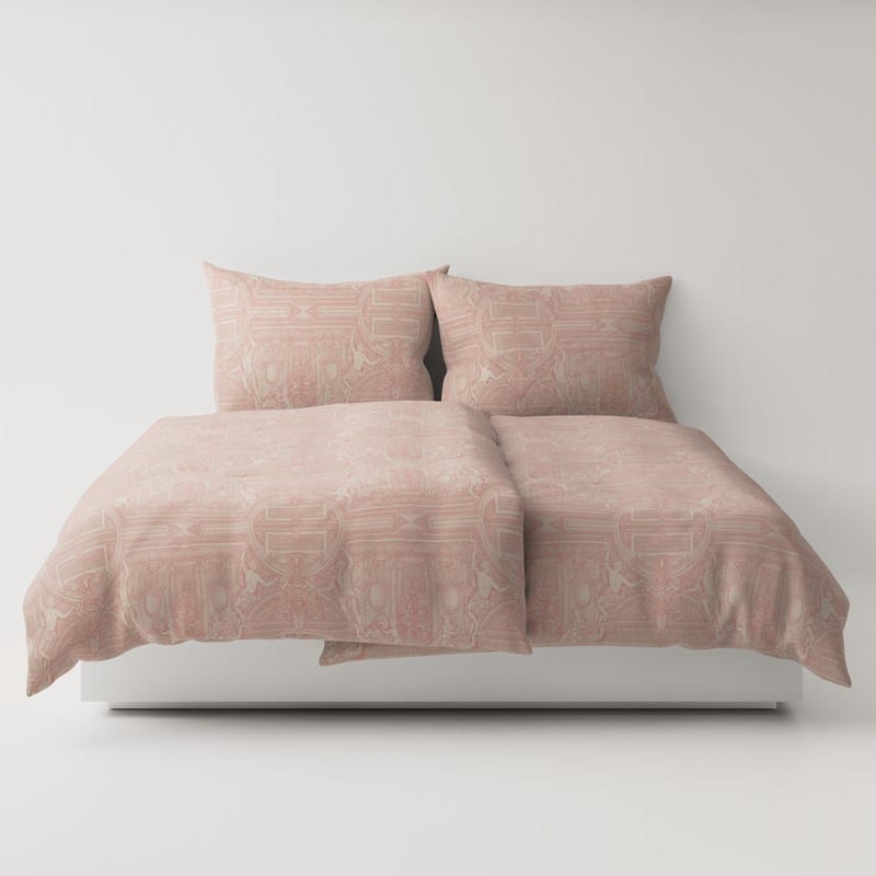 A bed with a pink comforter and two pillows.