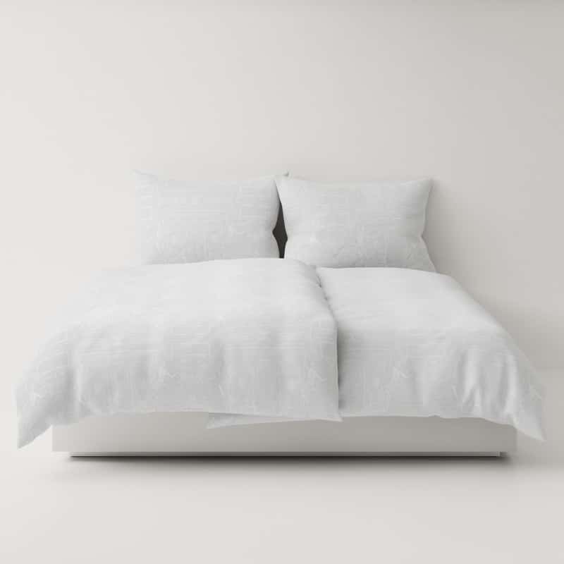 A bed with a white duvet and pillows.