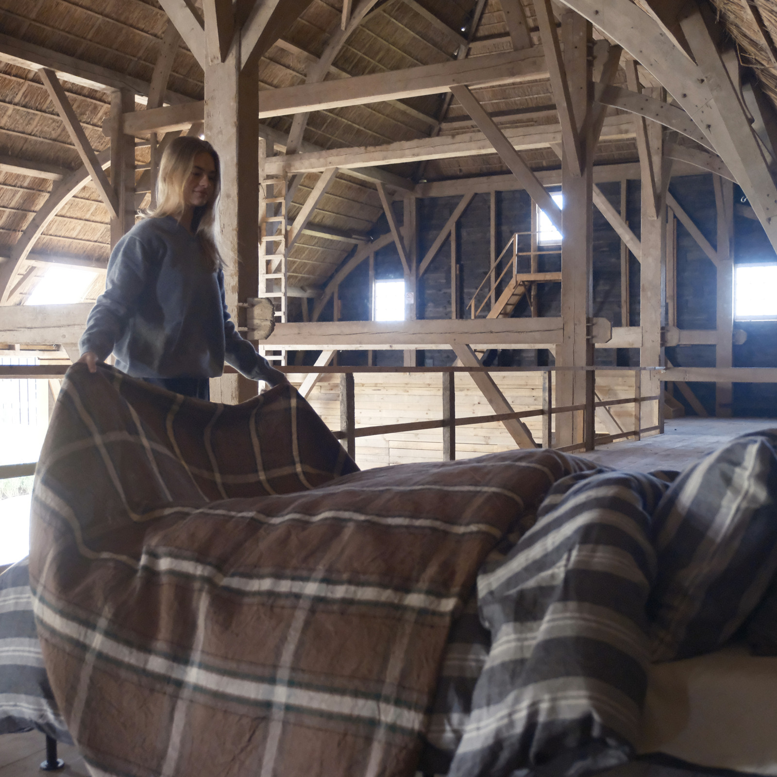 Eine Frau, die auf einem Bett in einem Loft steht.