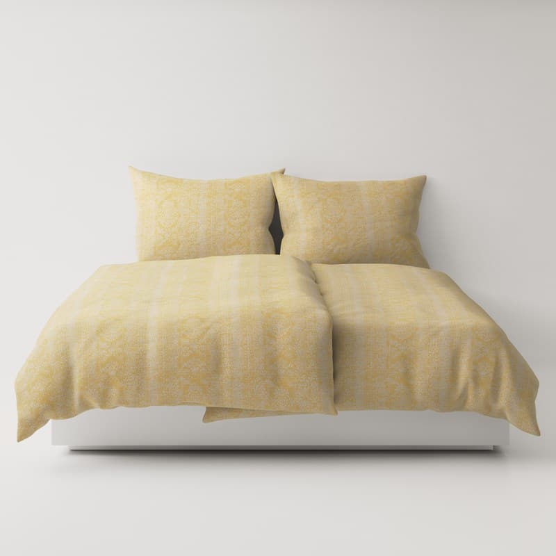 A bed with a yellow comforter and two pillows.
