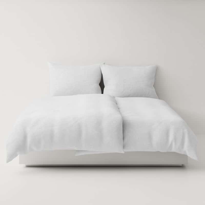 A bed with a white comforter and two pillows.