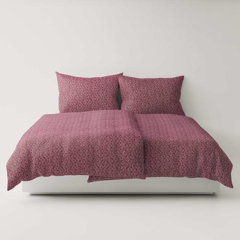 A bed with a pink comforter and two pillows.