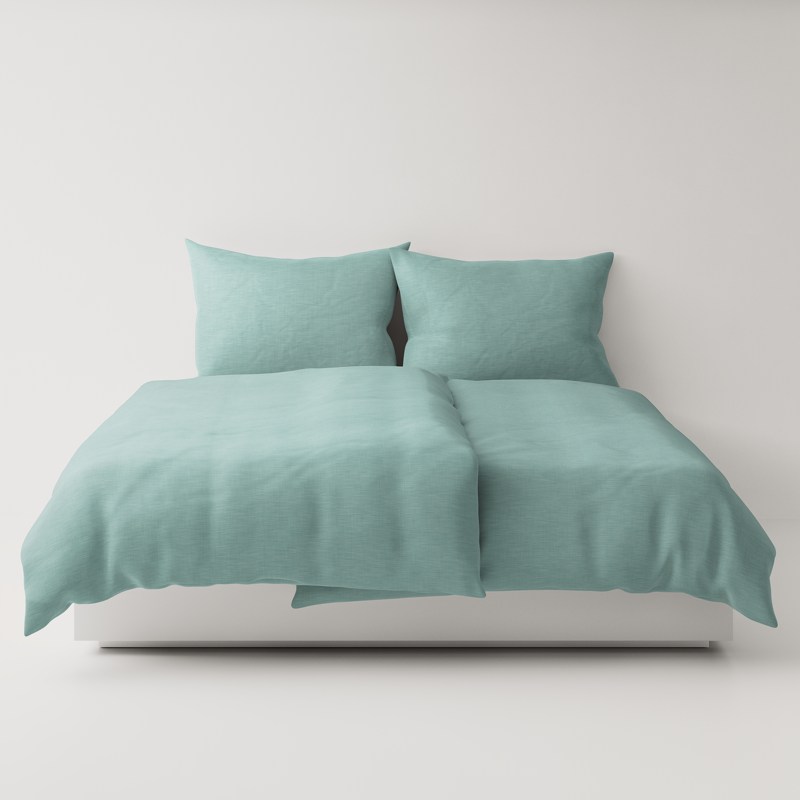 A bed with a green comforter and pillows.