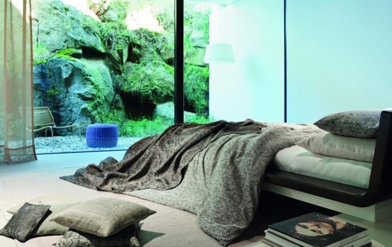 A bed in a bedroom next to a window.