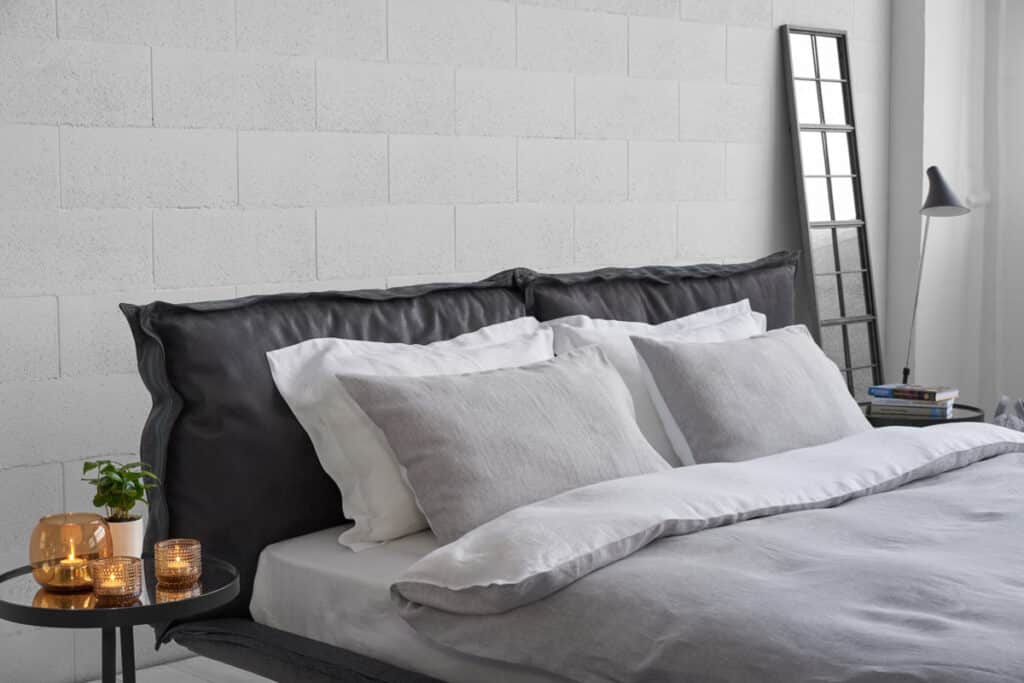 A bed with white bedding and pillows in a bedroom.