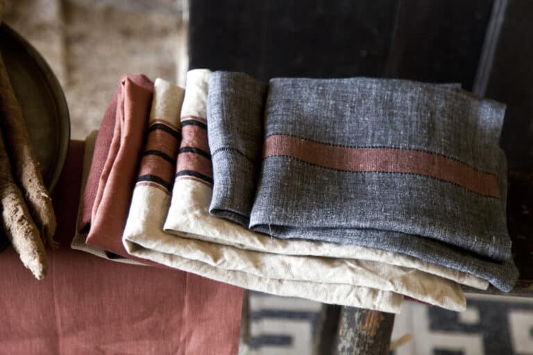 Ein Stapel gefalteter Handtücher, der auf einem Holztisch liegt.