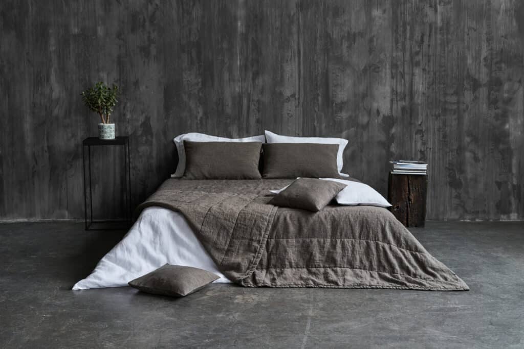 A bed with a blanket and pillows on it.