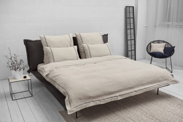 A bed in a bedroom next to a window.