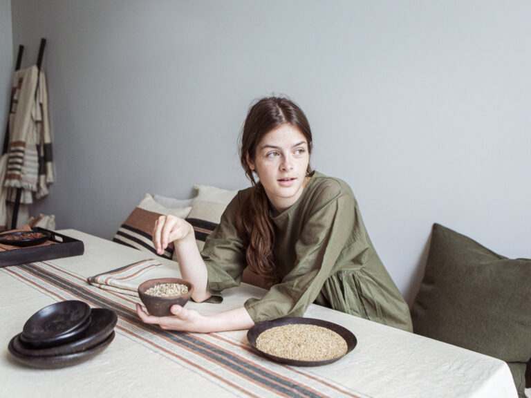 A woman sitting at a table with a plate full of food.