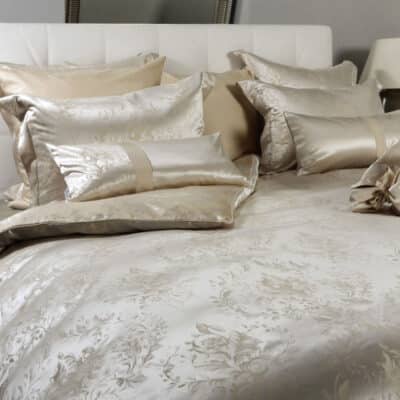 A bed with a white headboard and pillows.