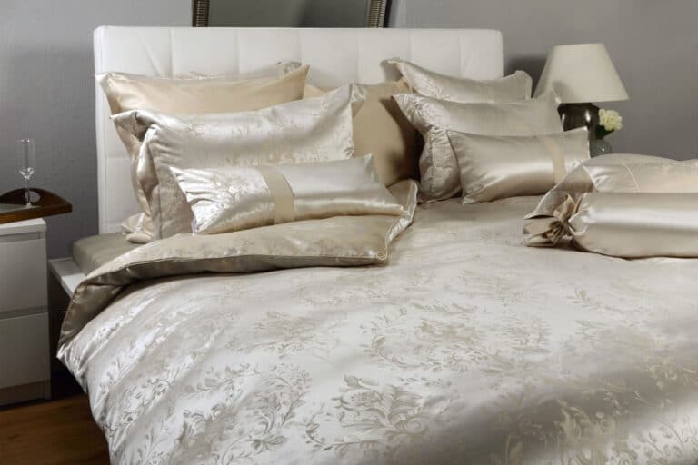 Ein Bett mit einem weißen Kopfteil und Kissen.