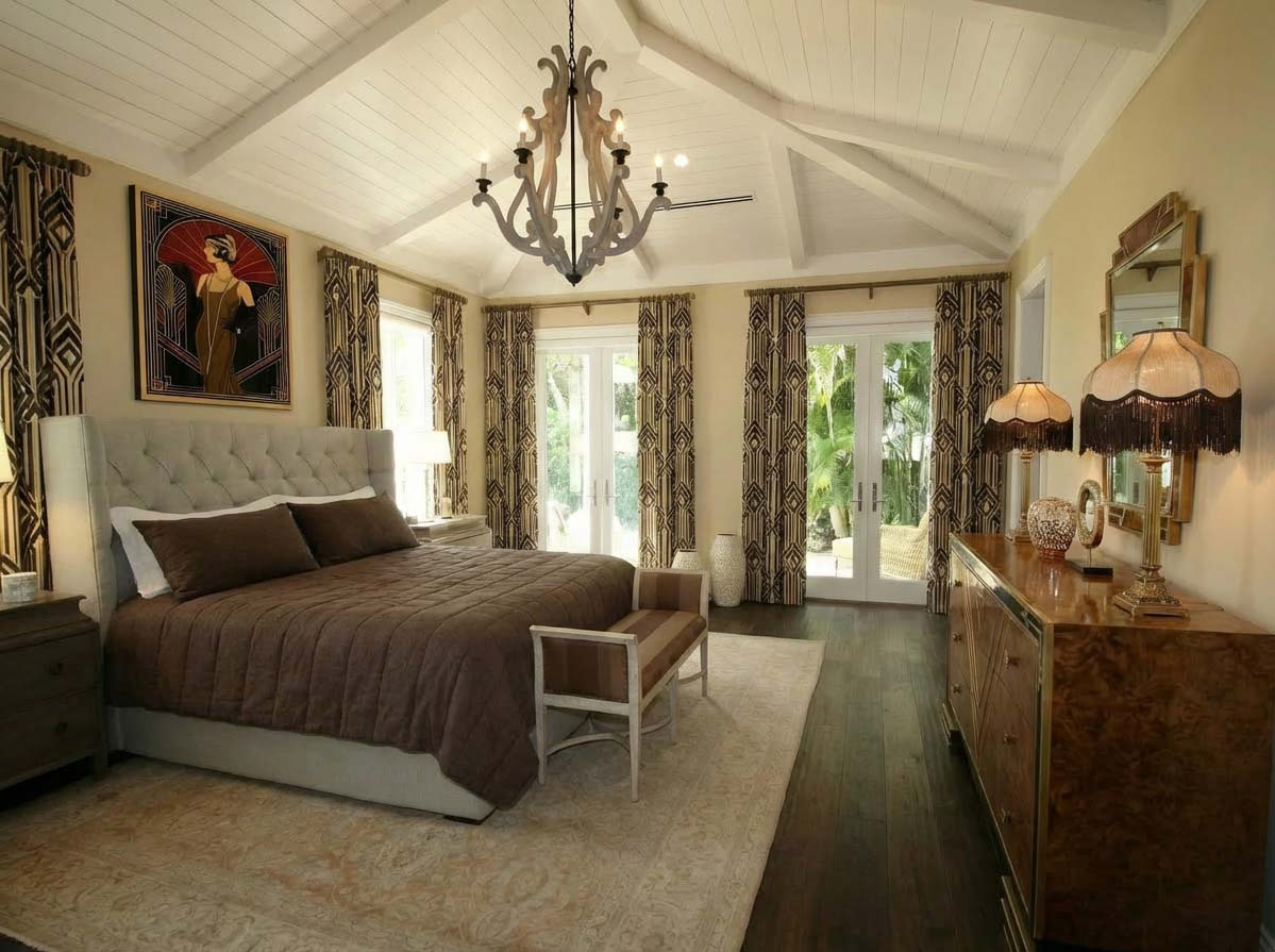A bedroom with a large bed and a chandelier.