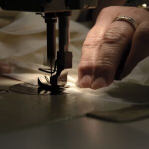 Eine Person, die eine Nähmaschine benutzt, um etwas zu nähen.