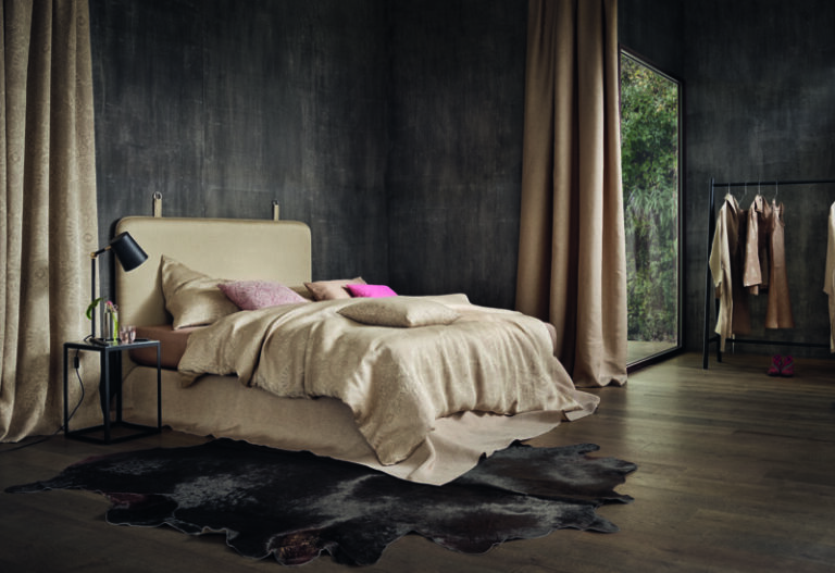 A bed in a bedroom next to a window.