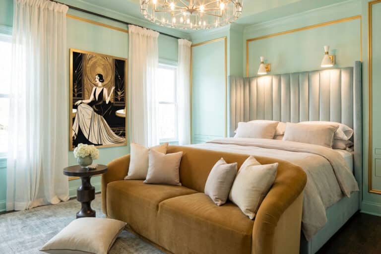 A bedroom with a large bed and a chandelier.