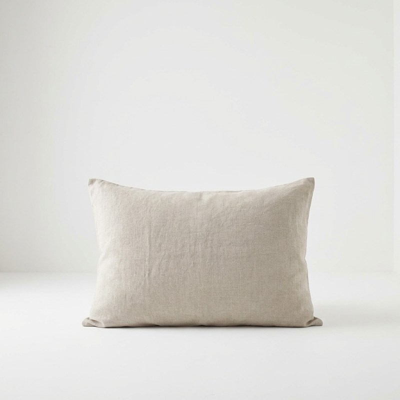 Ein weißes Kissen, das auf einem weißen Boden liegt.