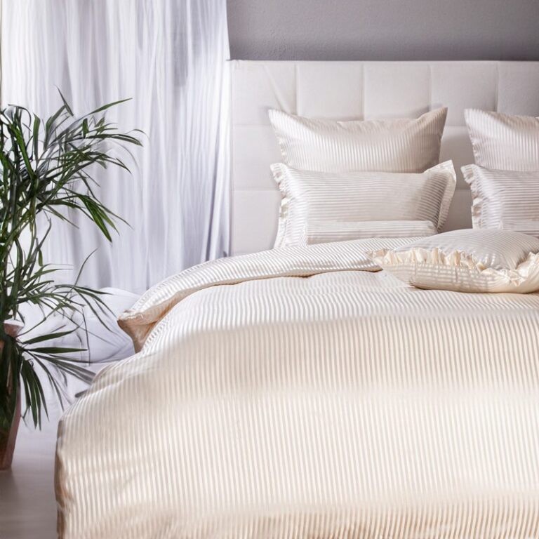 A bed with a white duvet and pillows.