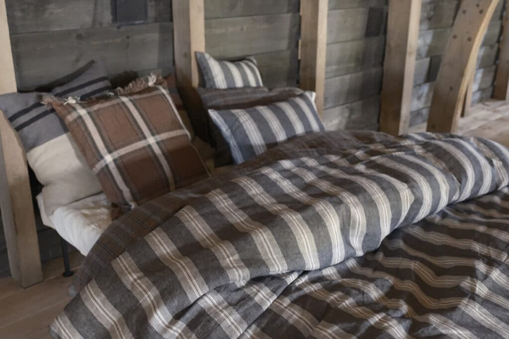 Ein Bett, auf dem ein Haufen Kissen liegt.