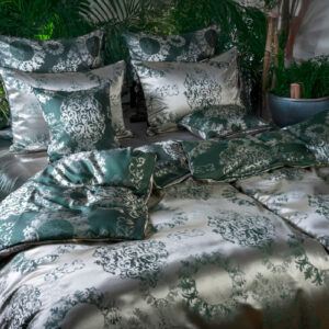 Ein Bett mit einer grün-weißen Bettdecke.