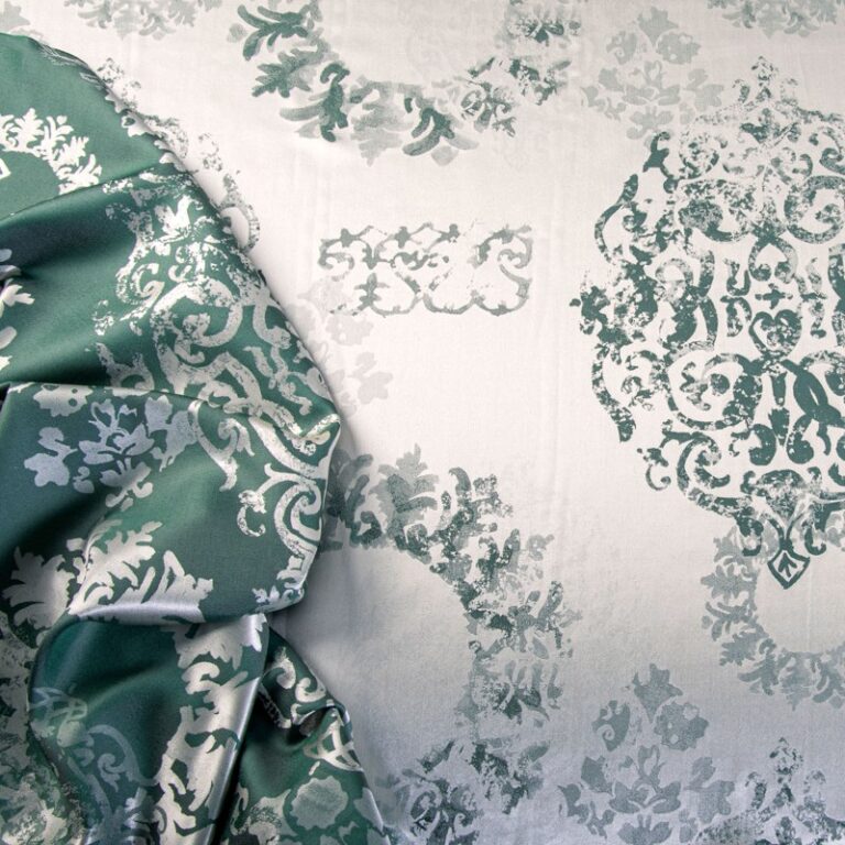 A bed with a green and white duvet on it.