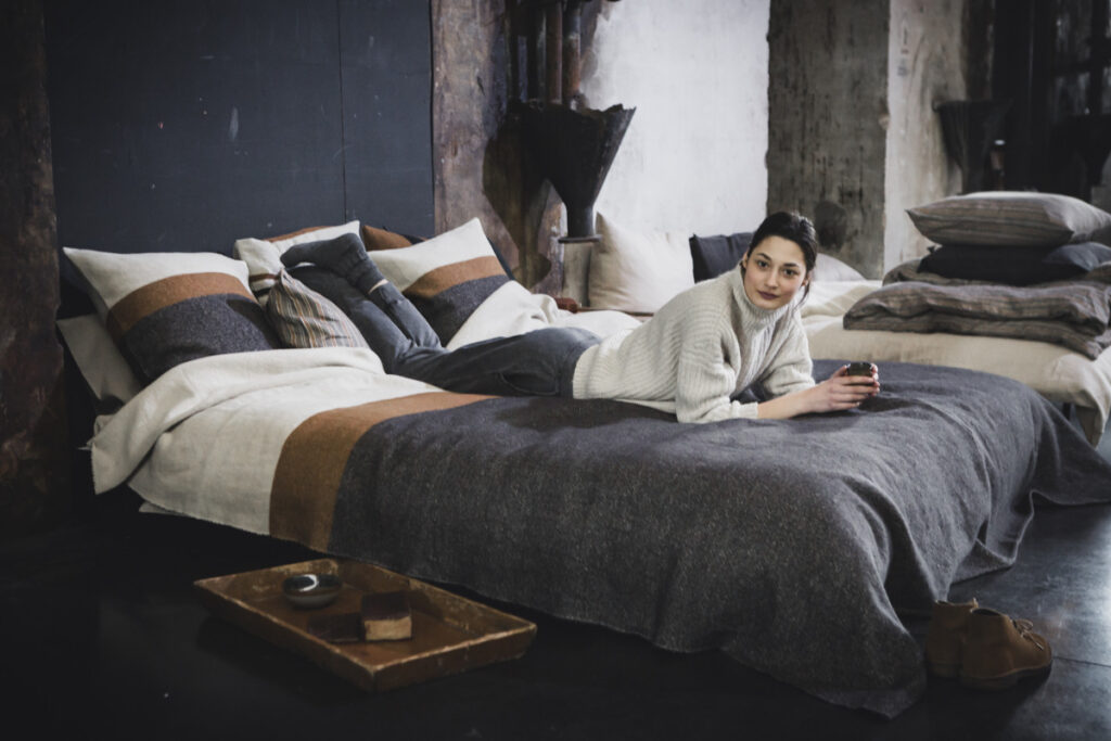 Eine Frau, die auf einem Bett mit einem Stapel von Kissen liegt.