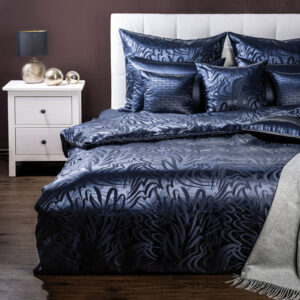 Ein Bett mit einer blauen Bettdecke und Kissen.