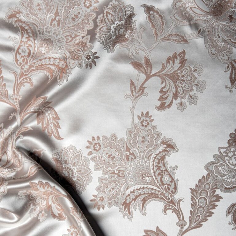 Close-up of a bed with a white-gold bedspread.