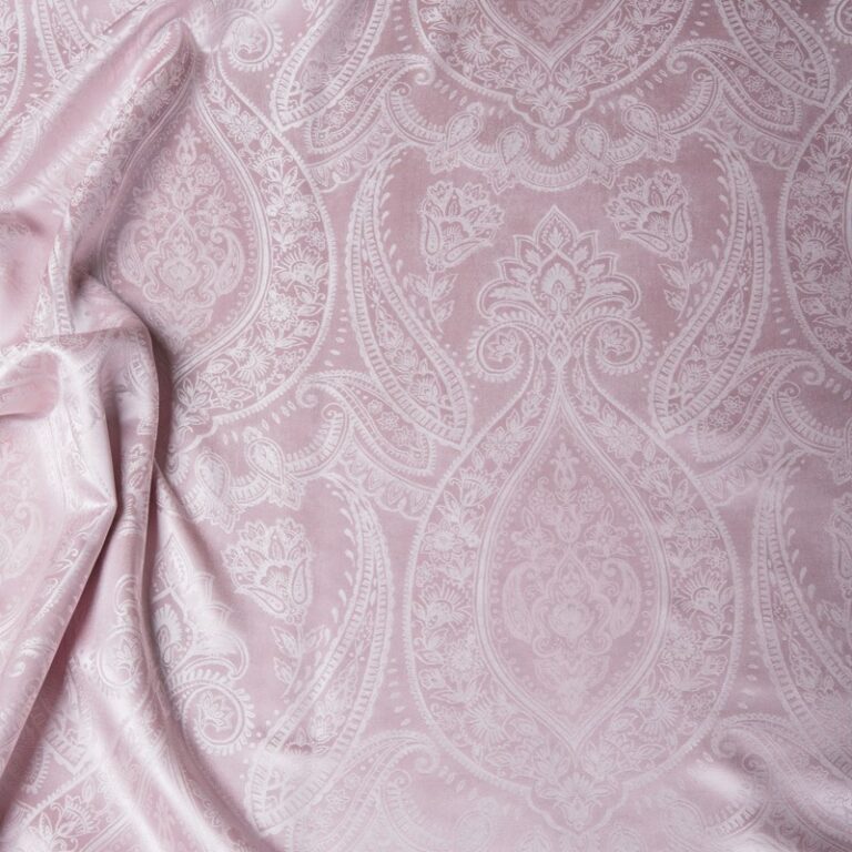 Eine Nahaufnahme eines Bettes mit einer rosa Bettdecke.