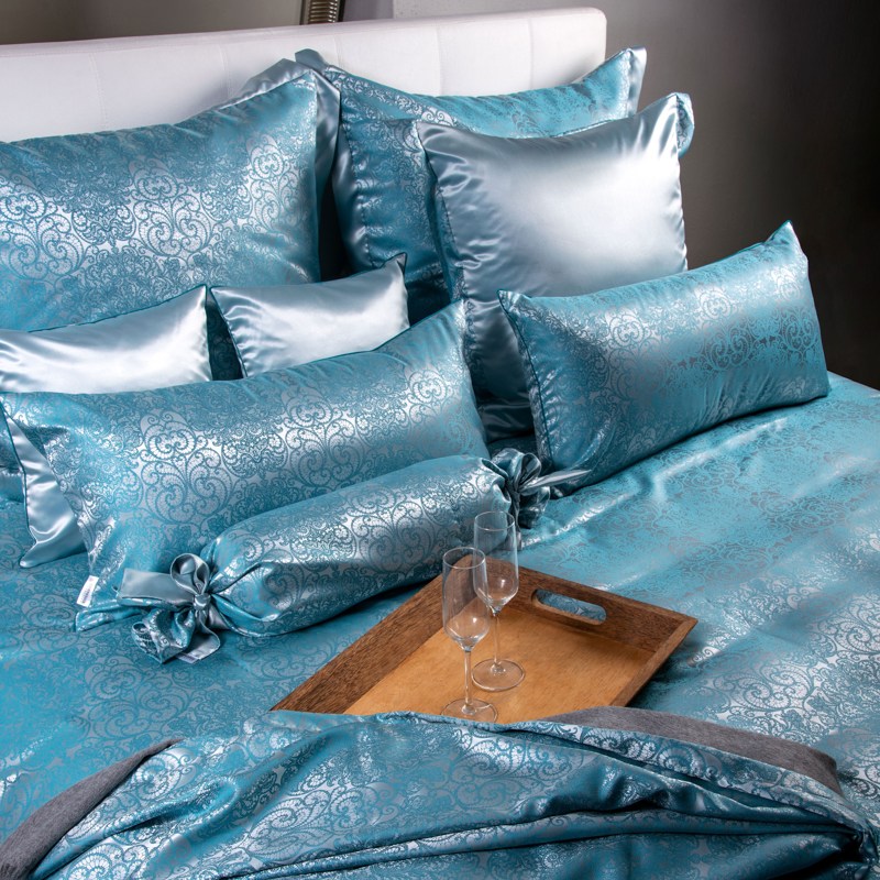 Ein Bett mit einer blauen Bettdecke und Kissen.