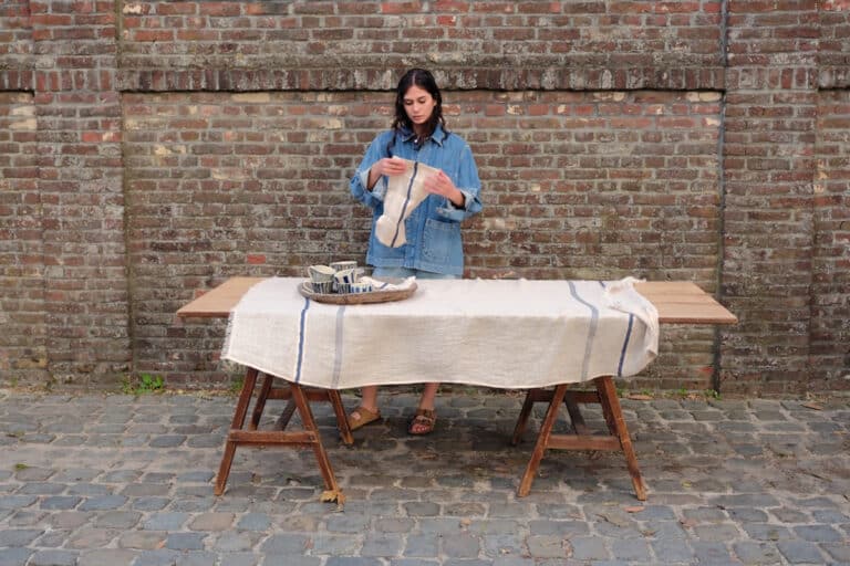 Eine Frau, die vor einem Tisch steht, auf dem eine Torte steht.