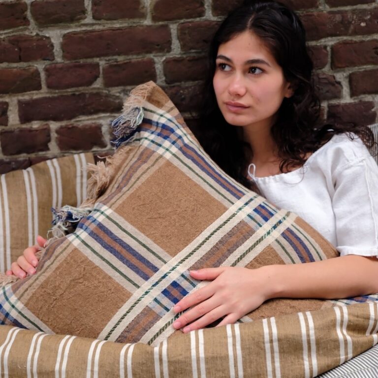 A woman lying on a bed covered with a blanket.