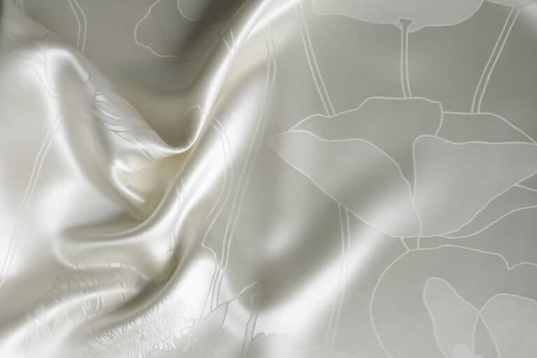 Ein weißes Laken mit einem Blumenmuster darauf.