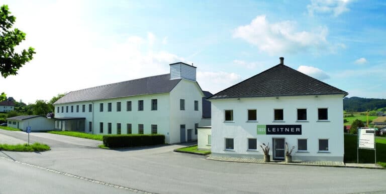 Ein großes weißes Gebäude, das am Straßenrand steht.